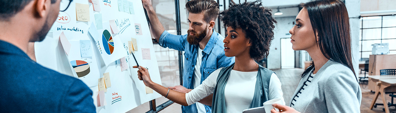 A diverse group of people planning with charts in a business setting.